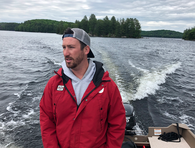 Image of Hawkona's owner, Greg Wood, wearing a red rain coat on a boat.